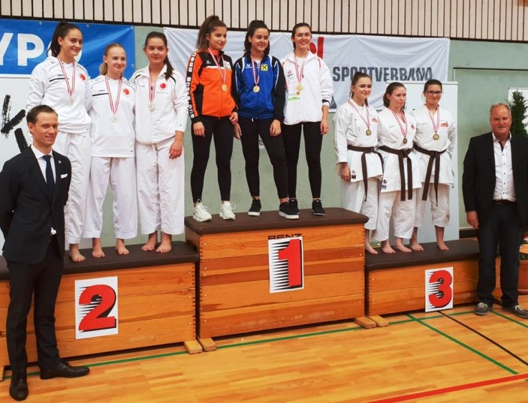 Selina Keskin Gold in Team-Kata (Bildmitte, orange Jacke)